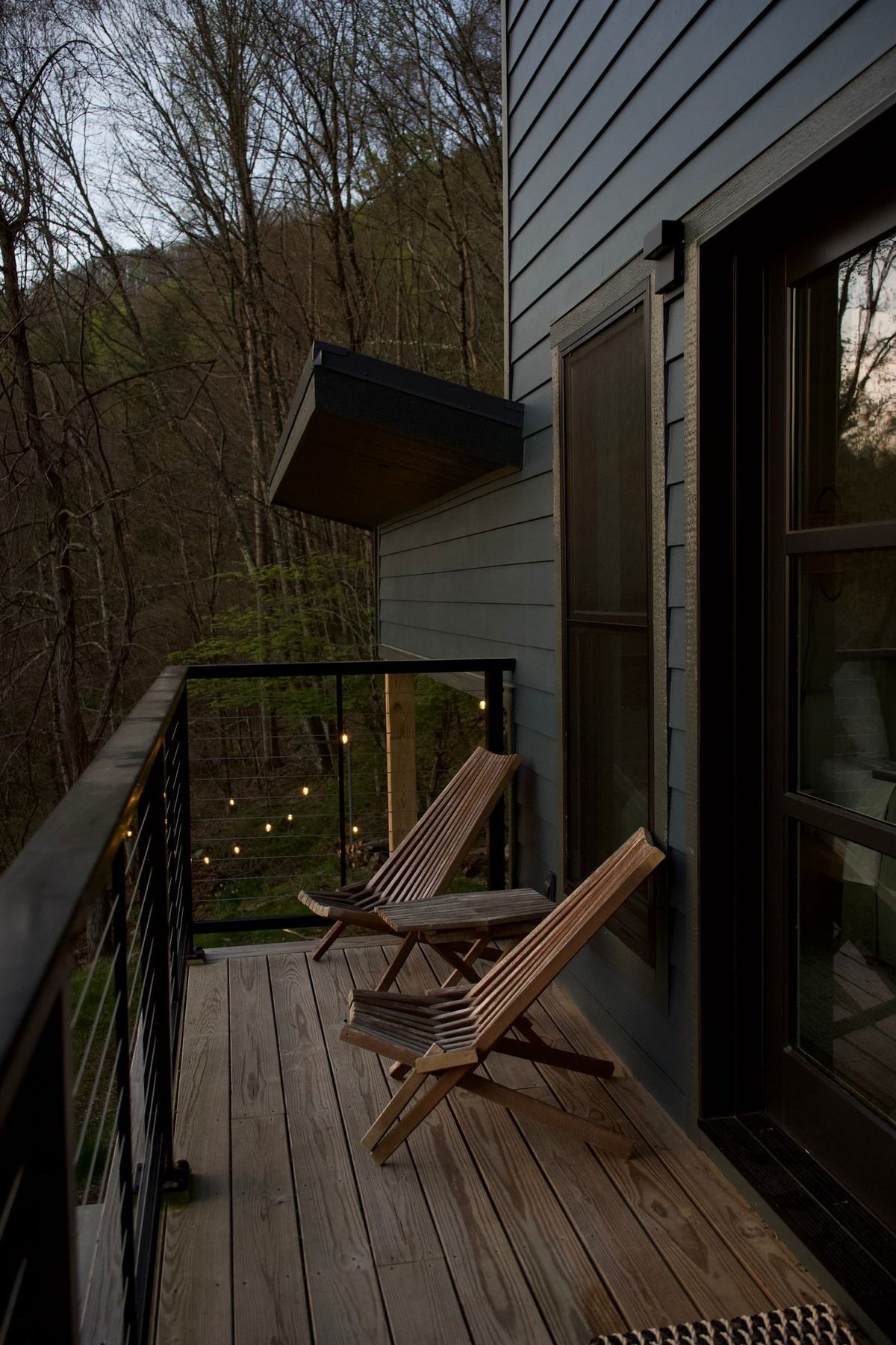 Raised deck with cable balustrade and wooden chairs