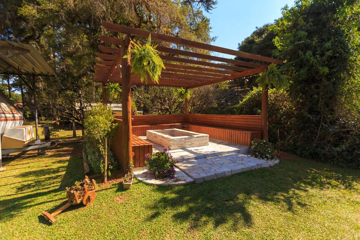 Wooden pergola over a paved seating area in a garden